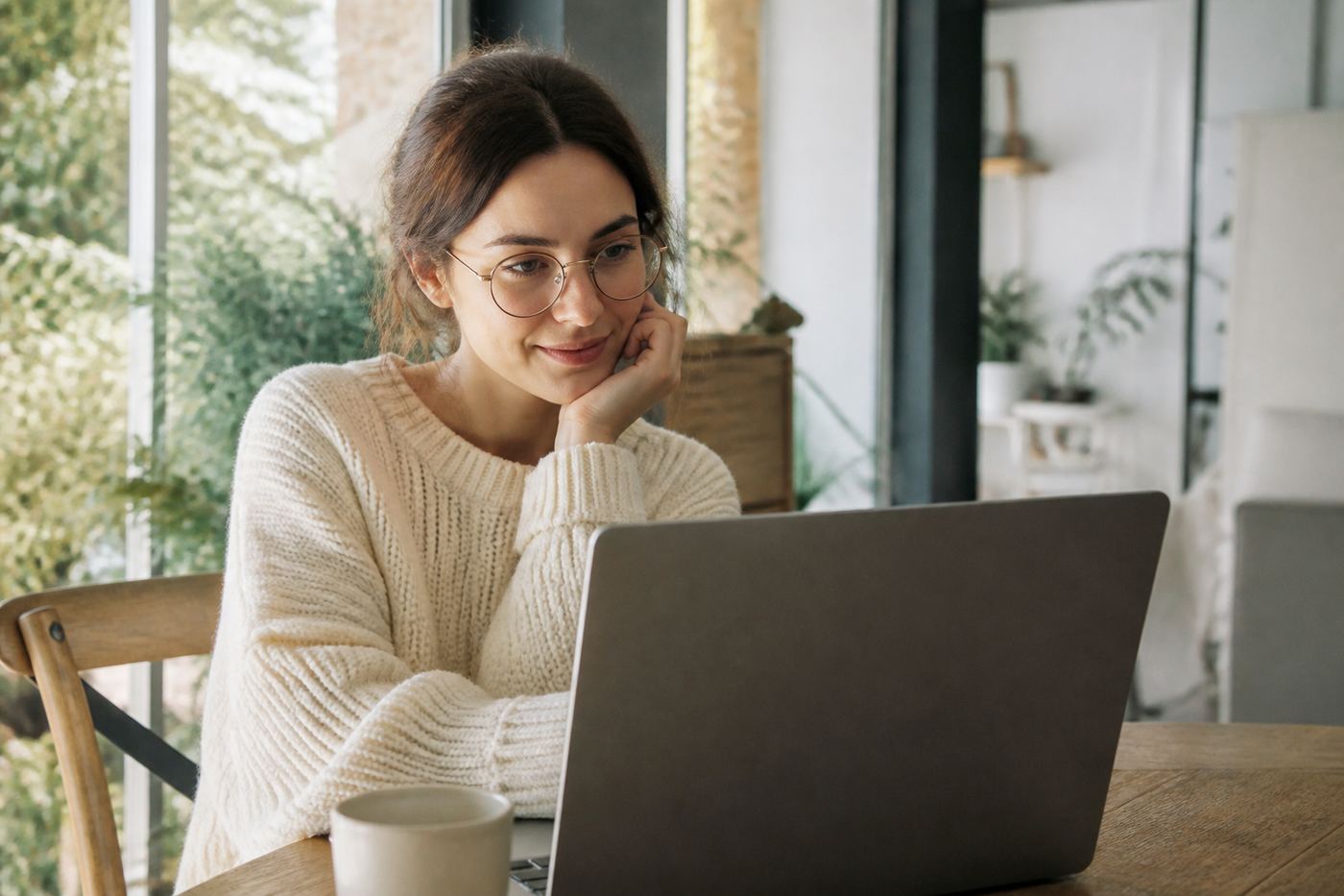 Young woman with glasses working on a laptop